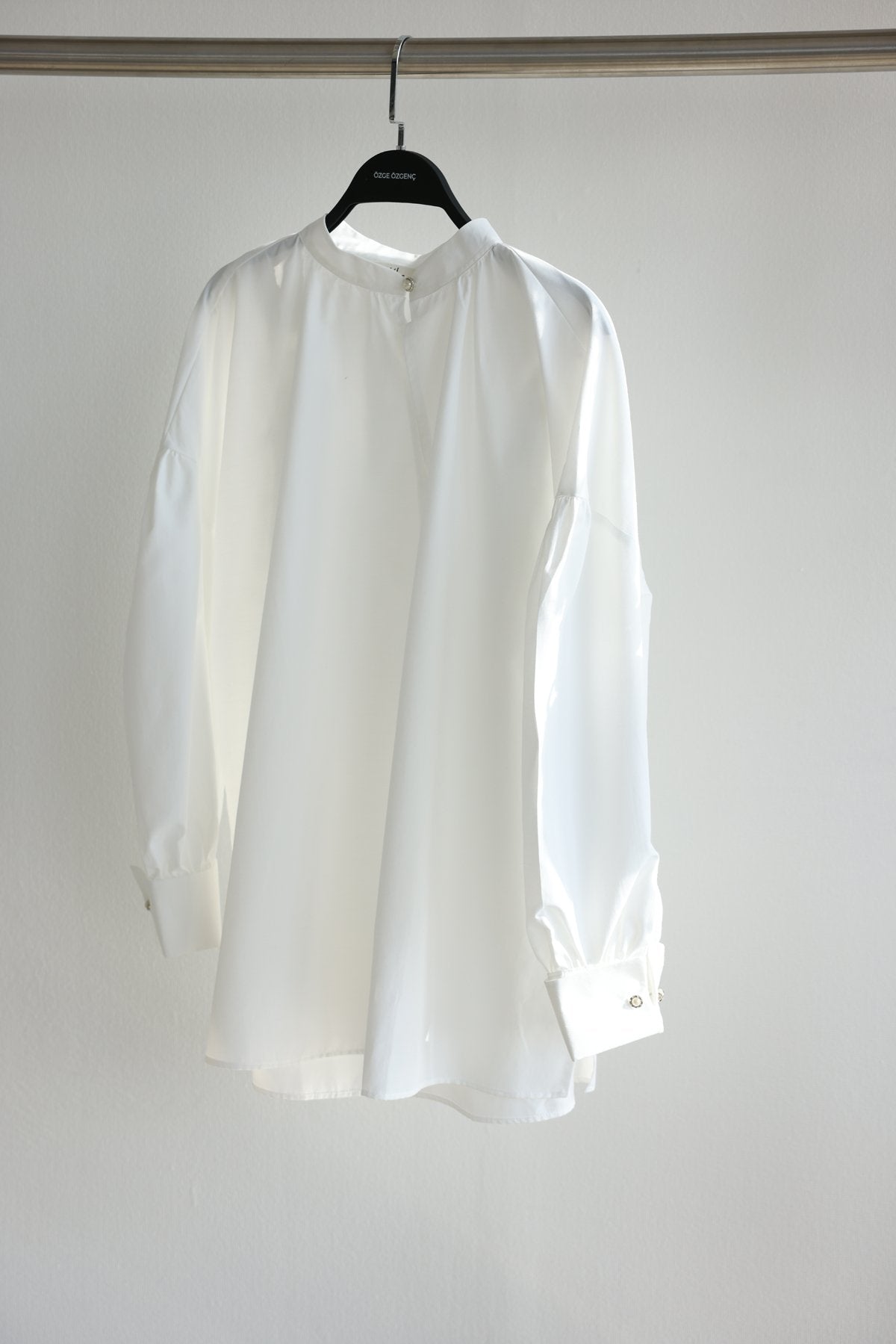 Oversize blouse with pearl buttons on the collar